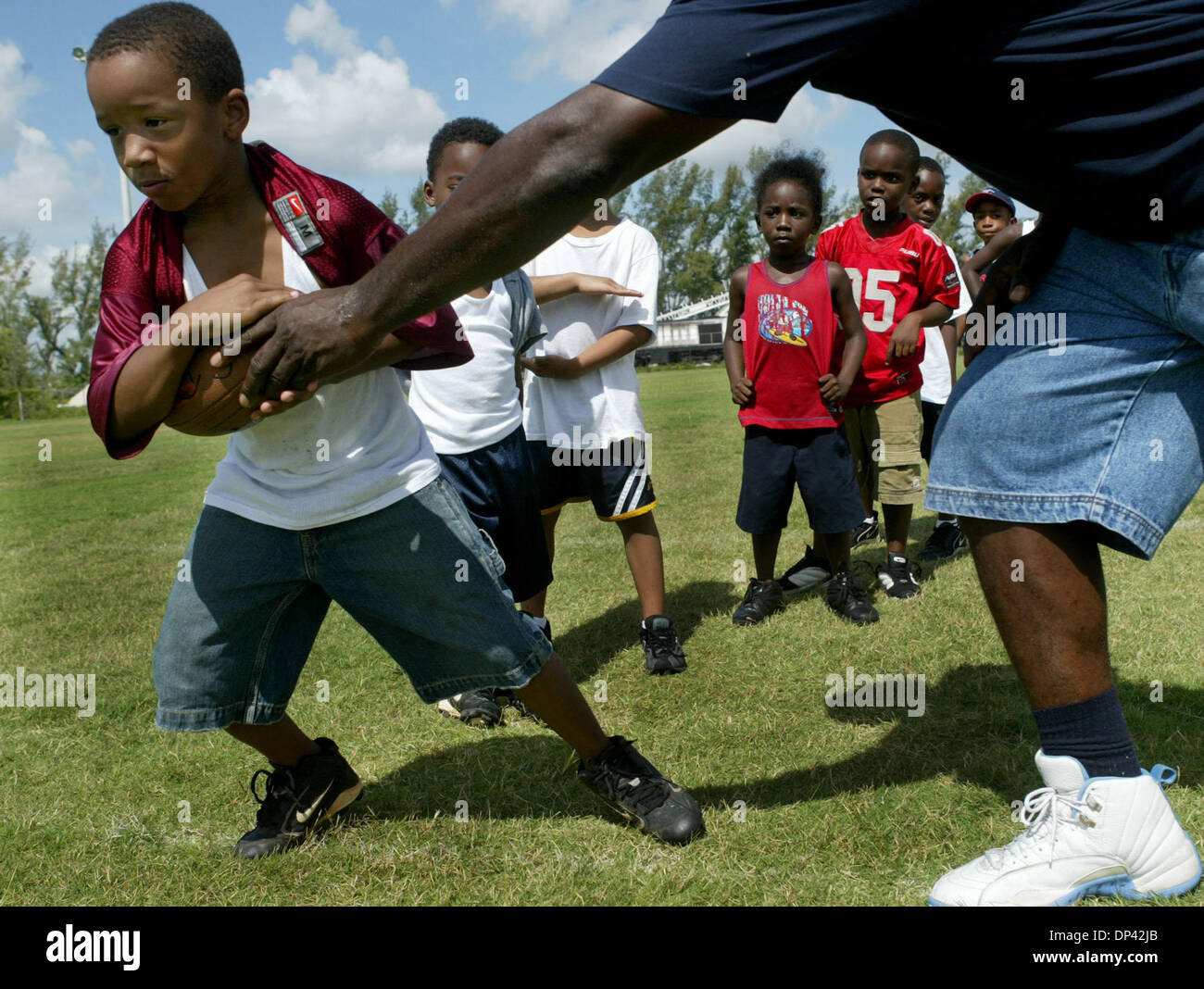 22. Juli 2006; Riviera Beach, FL, USA; Sechs-jährige Bryan Howzell Praktiken unter den Fußball von Kenneth Payne während der Barrett grün Fußballcamp Etablissement, dass Dan Calloway Freizeit. Payne ist die Direktorin des Zentrums von Wells Erholungszentrum. Profi-Fußballer, die mit Kindern im Lager gearbeitet enthalten Suncoast Alaun, Barrett Green, Arizona Cardinals Jack Bre Stockfoto