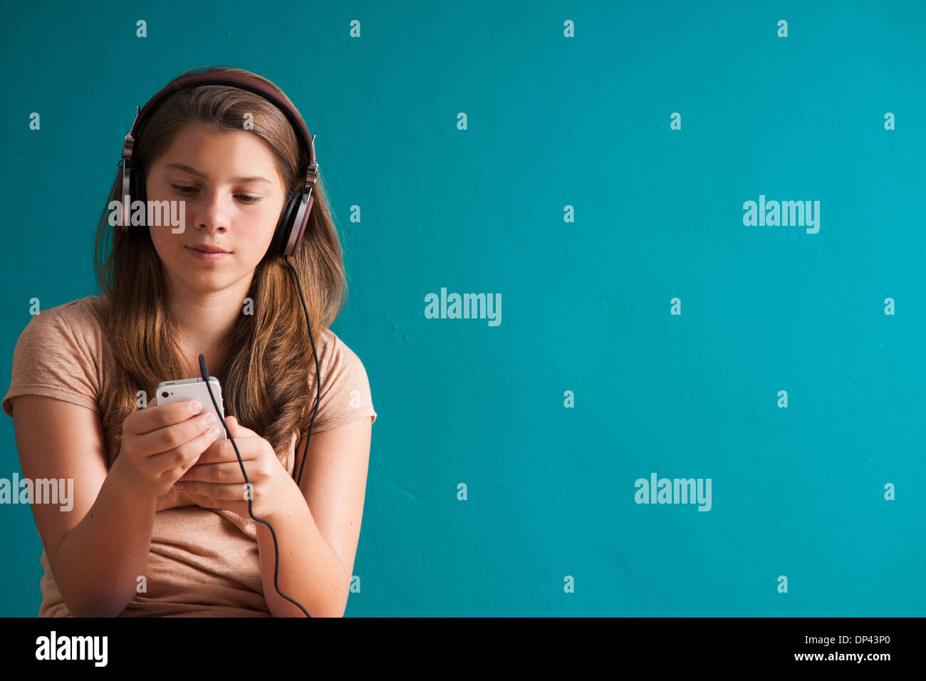 Mädchen mit Kopfhörern, Blick auf MP3-Player, Deutschland Stockfoto