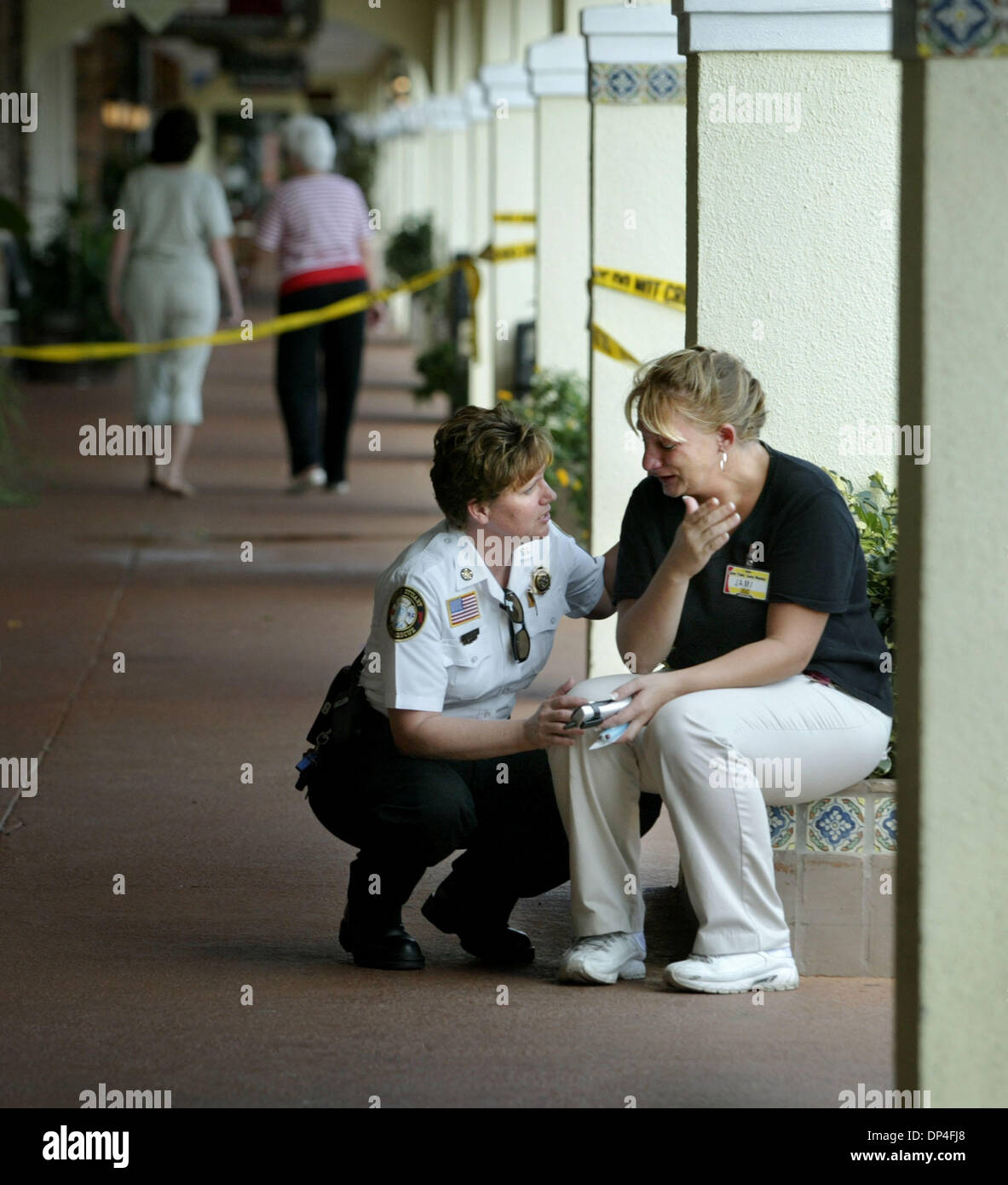 10. August 2006; Stuart, FL, USA; Stuart Fire Rescue Chief Lori Sunderman, links, Konsolen der Dollar General Mitarbeiters 911 wird aufgerufen, wenn Kunden ihr totes Kind in einem LKW im Cedar Pointe Plaza Donnerstag gefunden. Die Frau hatte ihr Kind vergessen, während sie zur Arbeit ging und entdeckte die Leiche des Kindes beim Laden Lebensmittel auf den Rücksitz des Wagens, die sie fuhr. Mand Stockfoto