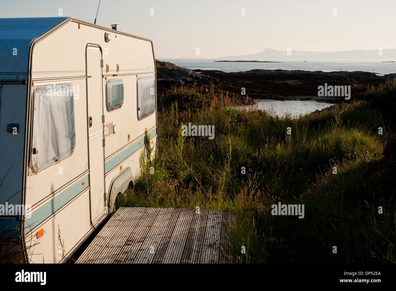 Alte Wohnwagen sitzen in einer erstklassigen Lage an der idyllischen Westküste Schottlands im schönen Abendlicht Stockfoto