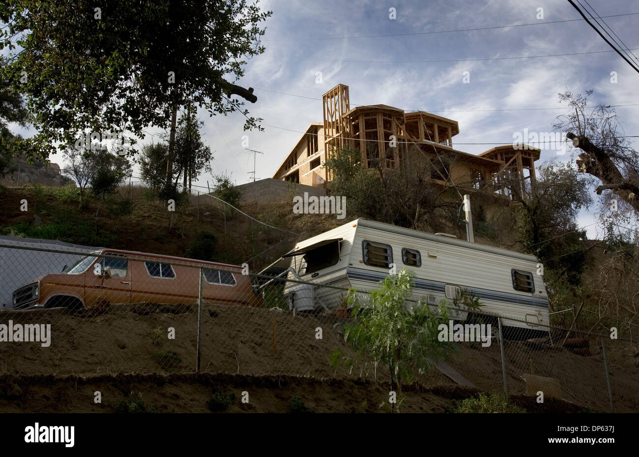 4. Oktober 2006; San Diego County, Kalifornien, USA; Ein neues Zuhause im Bau durch die Waldbrände in 2003 wieder aufgebaut mit Blick auf einen Anhänger eines Hauses auf Niles-Straße, die noch nicht mit dem Wiederaufbau beginnen. Mehr als 100 Häuser zerstört während der Brände haben noch nicht den Wiederaufbau beginnen und ihren Besitzern von San Diego County, die sie nicht mehr, in t leben können gemeldet worden Stockfoto