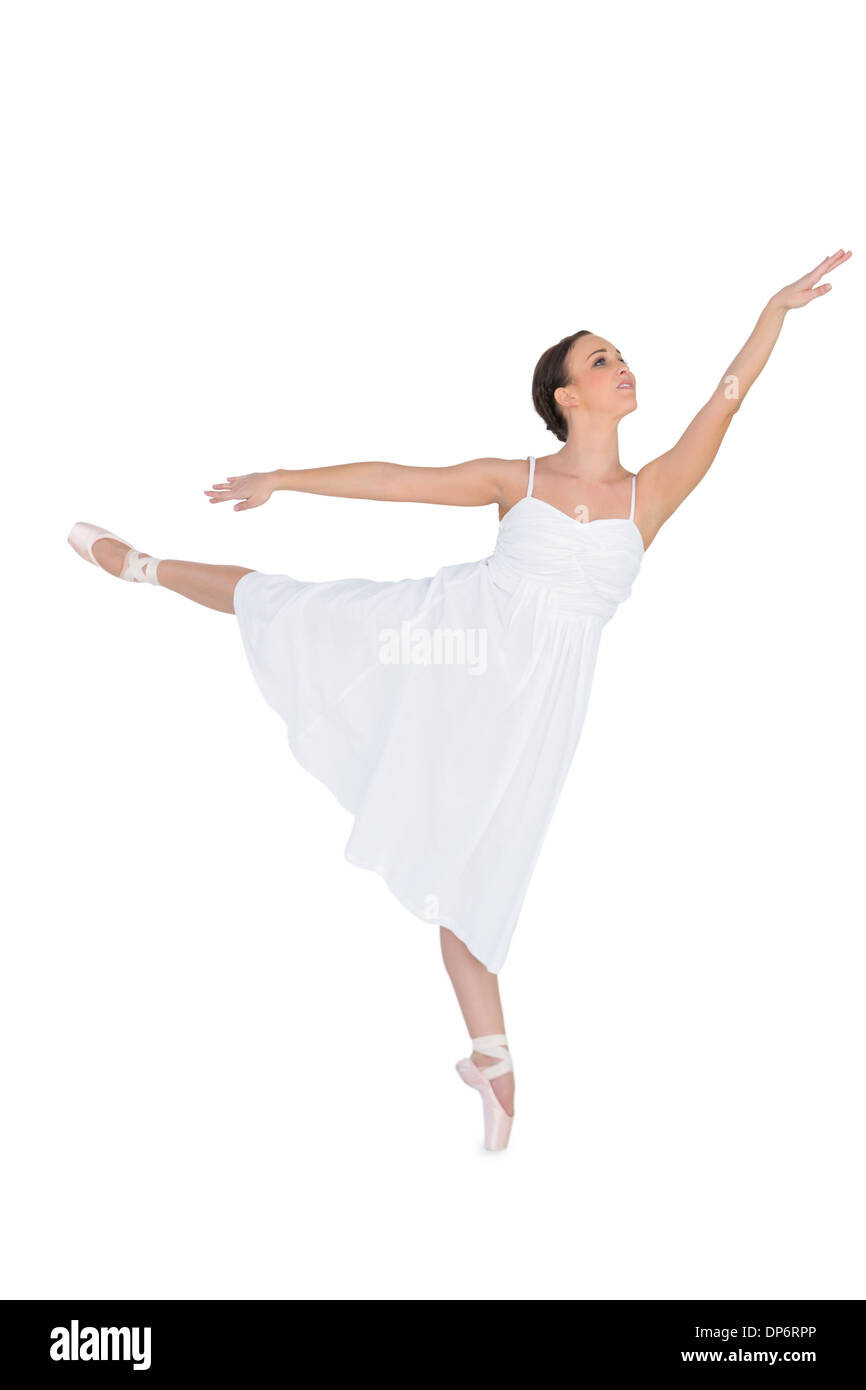 Fokussierte Balletttänzerin posiert auf ihren Zehenspitzen während steigt ein Bein Stockfoto