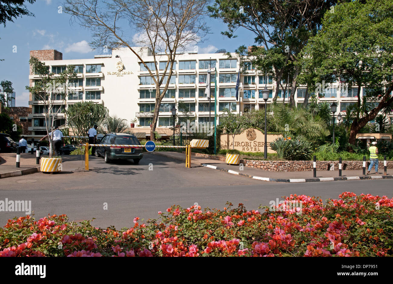 Eingang zum Nairobi Serena Hotel Parkplatz mit doppelten Barrieren für Sicherheit und Bougainvillea Blumen Stockfoto