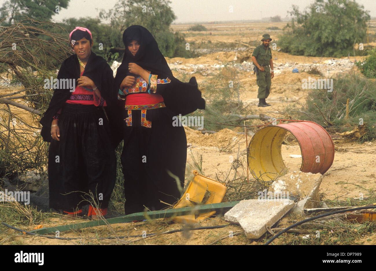 Beduinenindigene Frauen in traditionellen Tüchern. Sie befinden sich in der ehemaligen israelischen Siedlung Yamit, die im Rahmen des ägyptisch-israelischen Friedensvertrags niedergeschlagen wurde. Israelischer Soldat bewacht die Überreste der Siedlung. Sinai Wüste Israel 1982.1980s HOMER SYKES Stockfoto