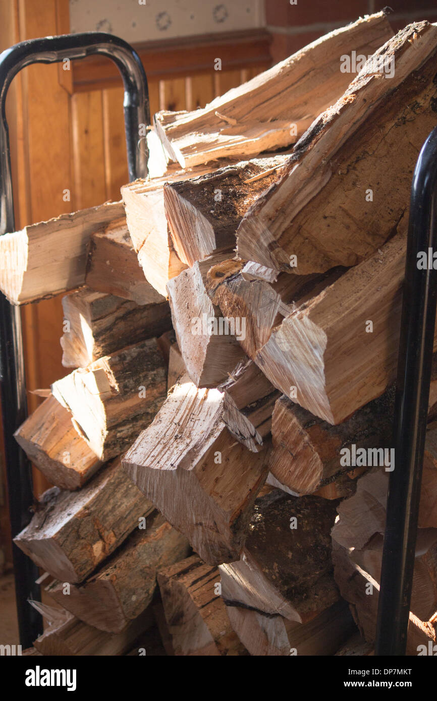 Haufen von Split Hartholz Brennholz in einem Stahltragwerk gespeichert. Stockfoto