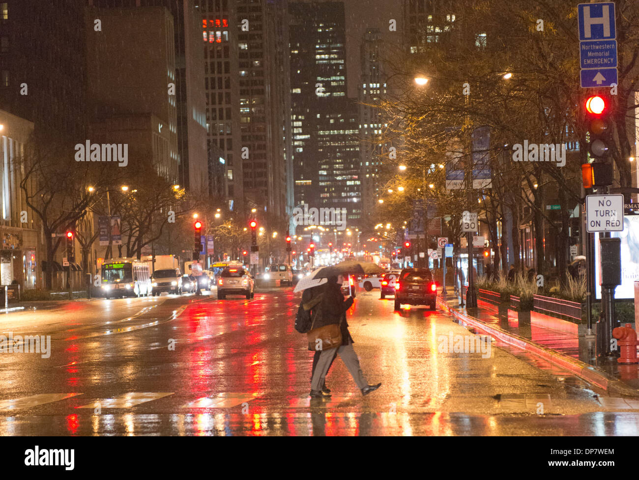 Ein paar überqueren Sie die Michigan Avenue an einem kalten, nassen, Winternacht. Stockfoto