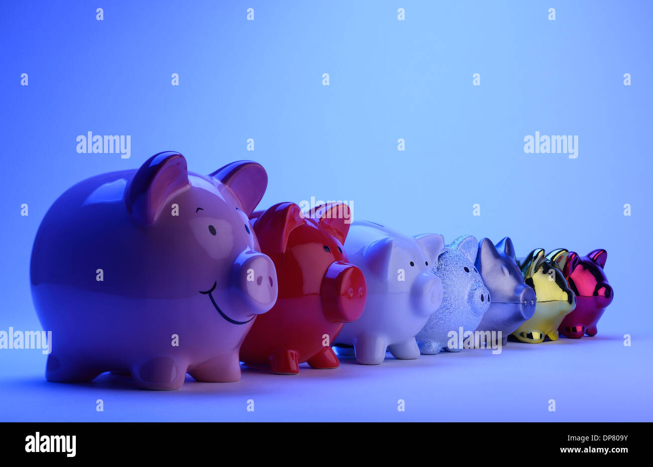 Sieben verschiedene Sparschweine in einer Linie Stockfoto