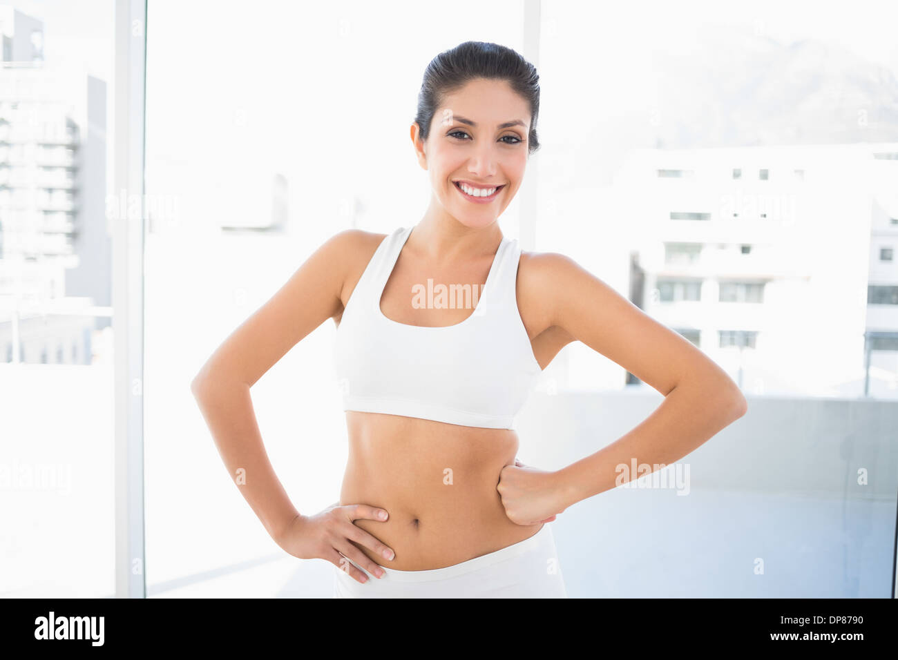 Fit glückliche Frau in Sportkleidung mit Händen auf den Hüften Stockfoto