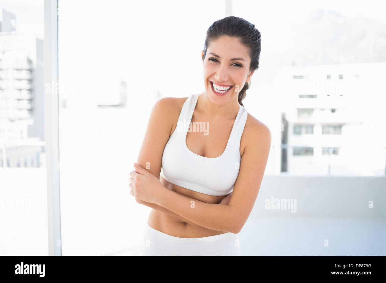 Fit lachende Frau in Sportkleidung mit verschränkten Armen Blick in die Kamera Stockfoto