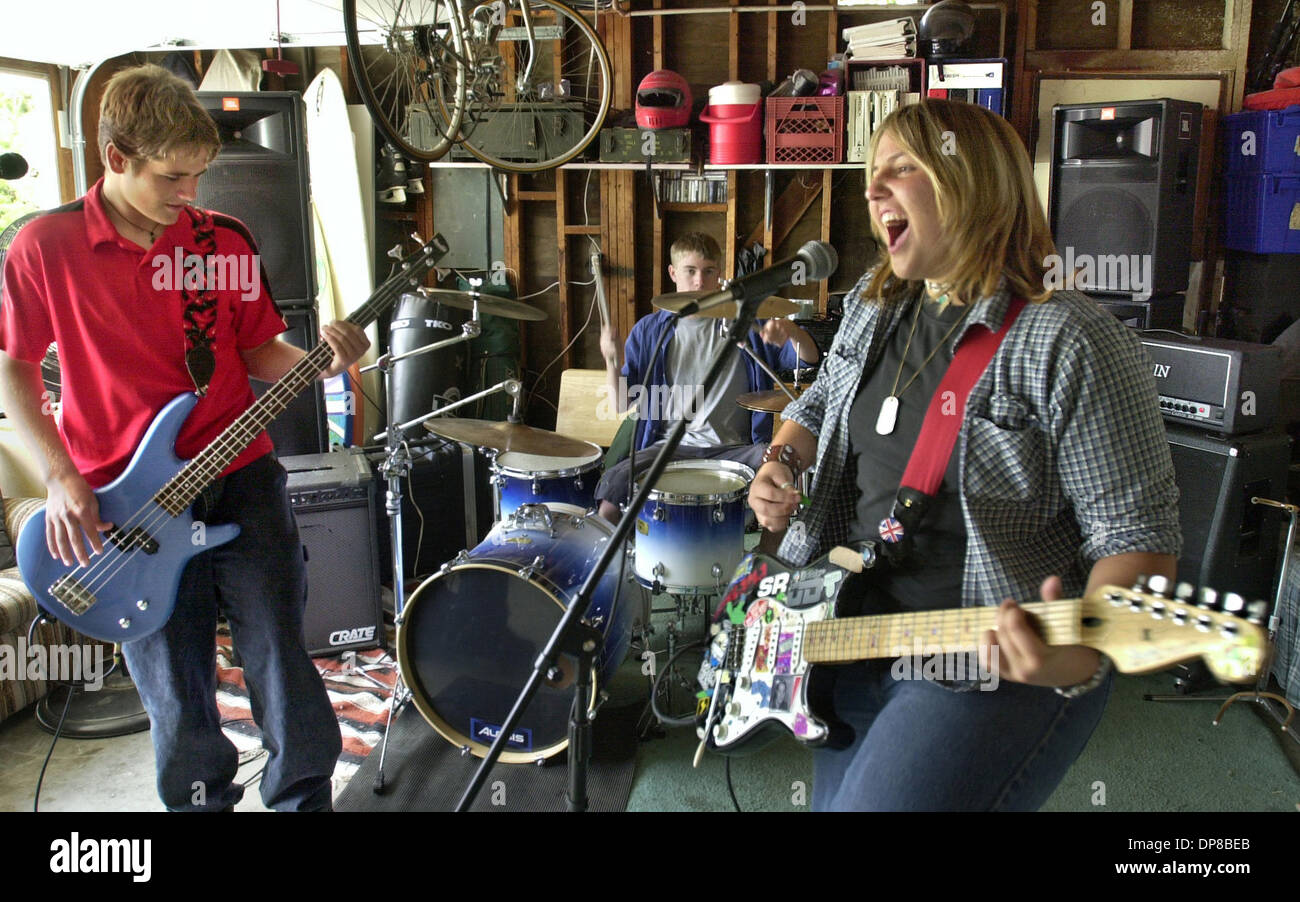 (Veröffentlicht 01.05.2003, NC-1): Muther Kinder (Cq) Praktiken in einer Garage in der Dreistadt von Oceanside in der Nähe von Landis Park. LtoR: LANCE HUDGINS am Bass, ROSS BOXALL am Schlagzeug und MARLENA COPADO an Gitarre und Gesang. Sie spielen in der Garage von Marlenas Großmutter.  U/T Foto CHARLIE NEUMAN Stockfoto