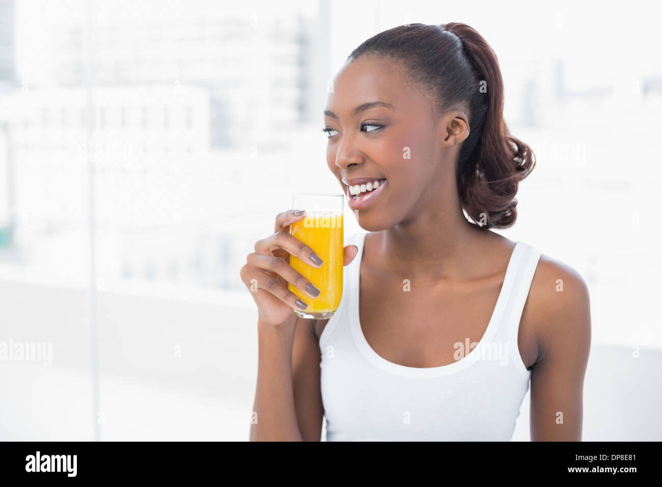 Fröhliche sportliche Modell mit Glas Orangensaft Stockfoto