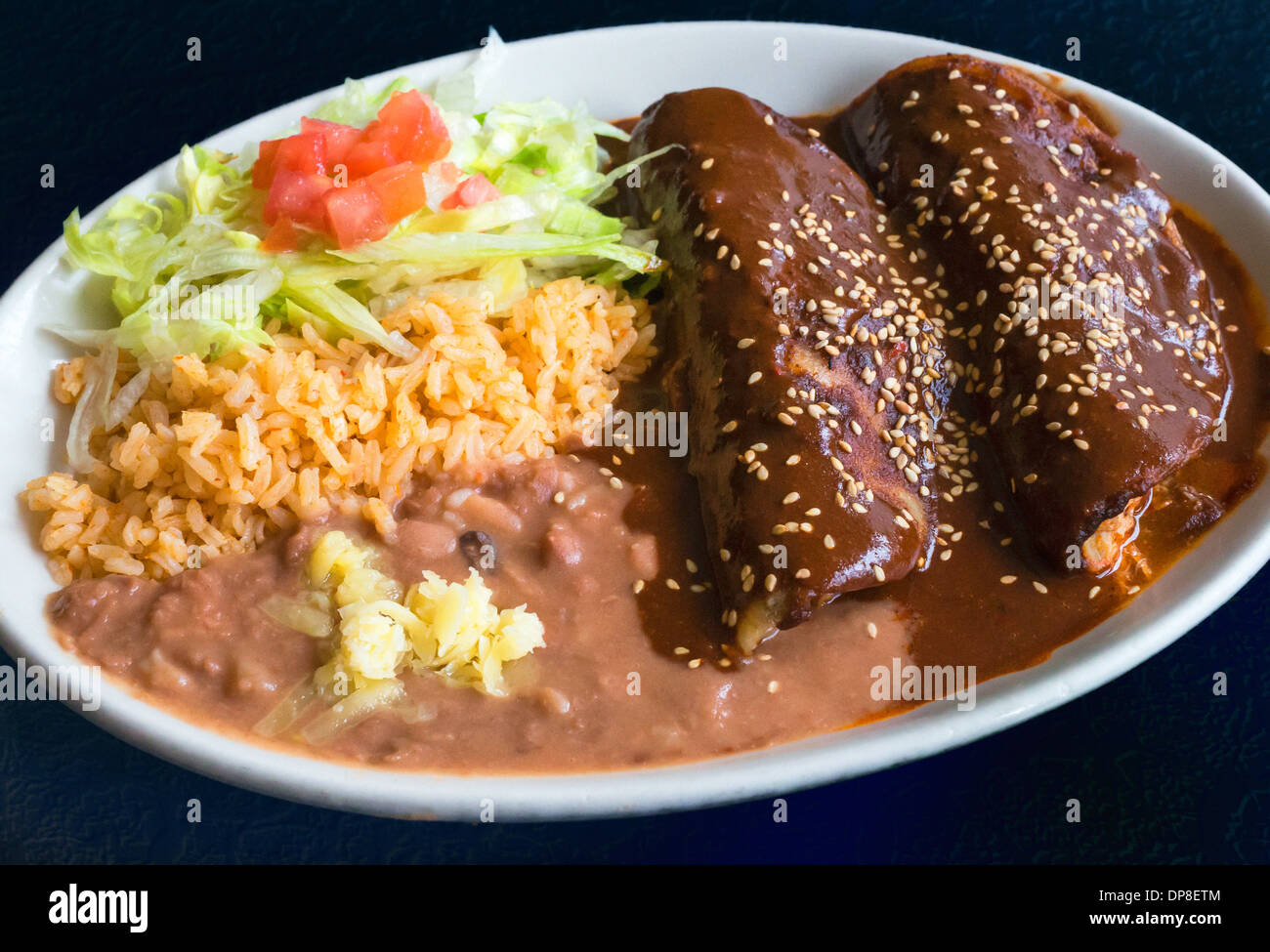 Enchiladas Maulwurf mit Reis, gebackenen Bohnen, Käse und Salat Stockfoto