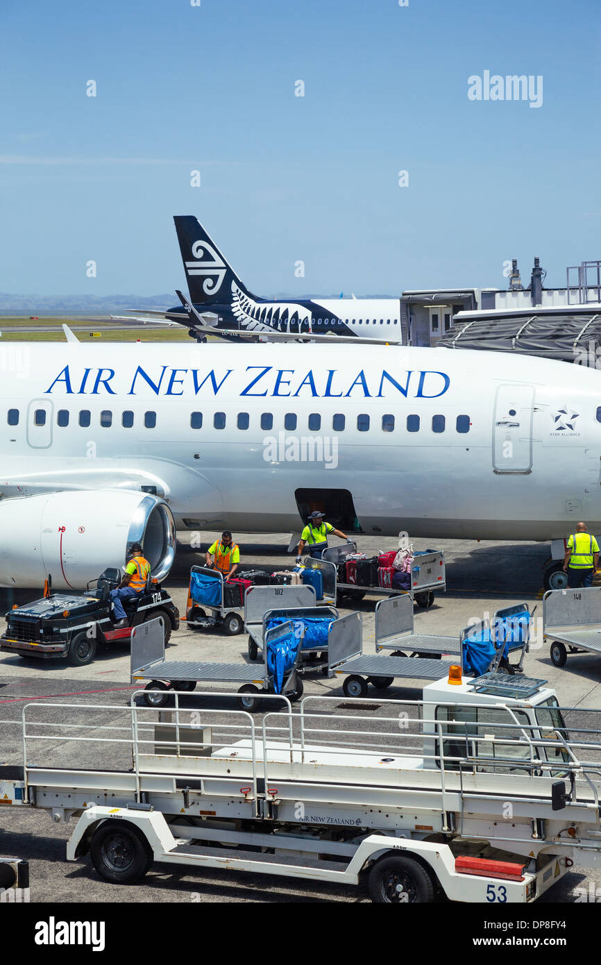 Gepäckabfertiger laden Koffer auf ein Flugzeug der Air New Zealand in Auckland Flughafen. North Island, Neuseeland. Stockfoto