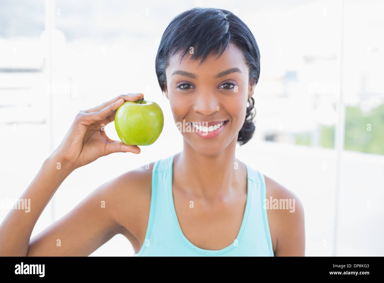 Attraktive schwarze behaarte Frau hält einen Apfel Stockfoto
