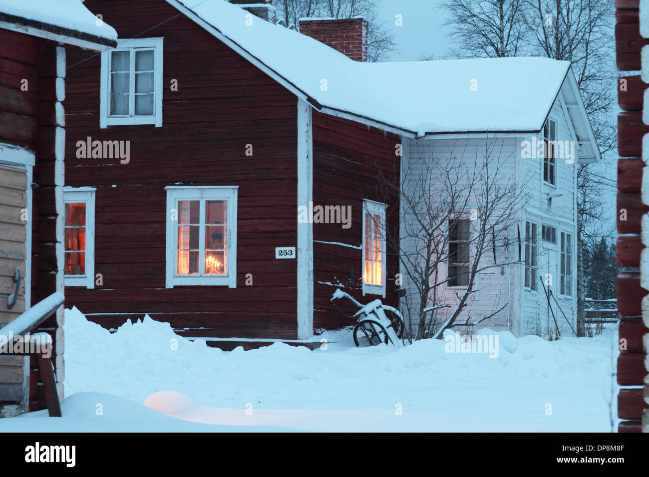 Holzhaus mit Weihnachtsstimmung im nordischen Winter mit Schnee rot Stockfoto