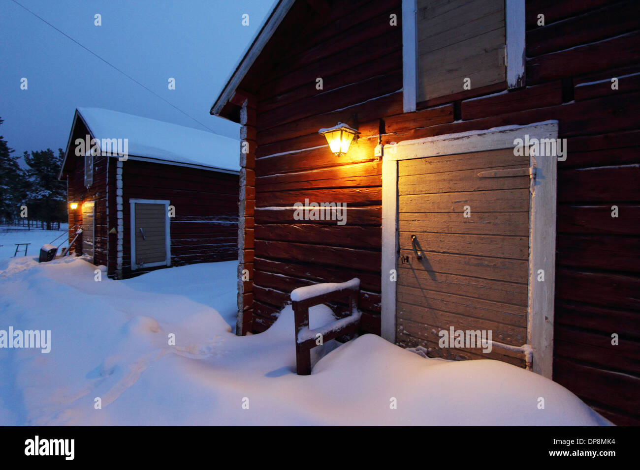 Holzhaus mit Weihnachtsstimmung im nordischen Winter mit Schnee rot Stockfoto