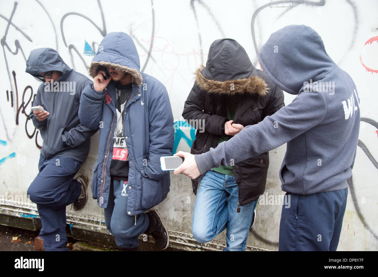 Eine Gruppe von Jungs im Teenageralter herumhängen, posieren in einer Straße, auf der Suche einzuschüchtern und zu bedrohen. Stockfoto