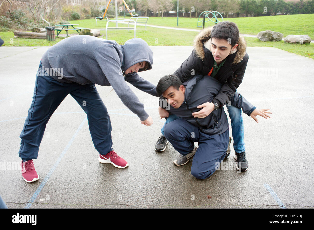 Ein Teenager, der von einer Gruppe von jungen angegriffen wird. Stockfoto