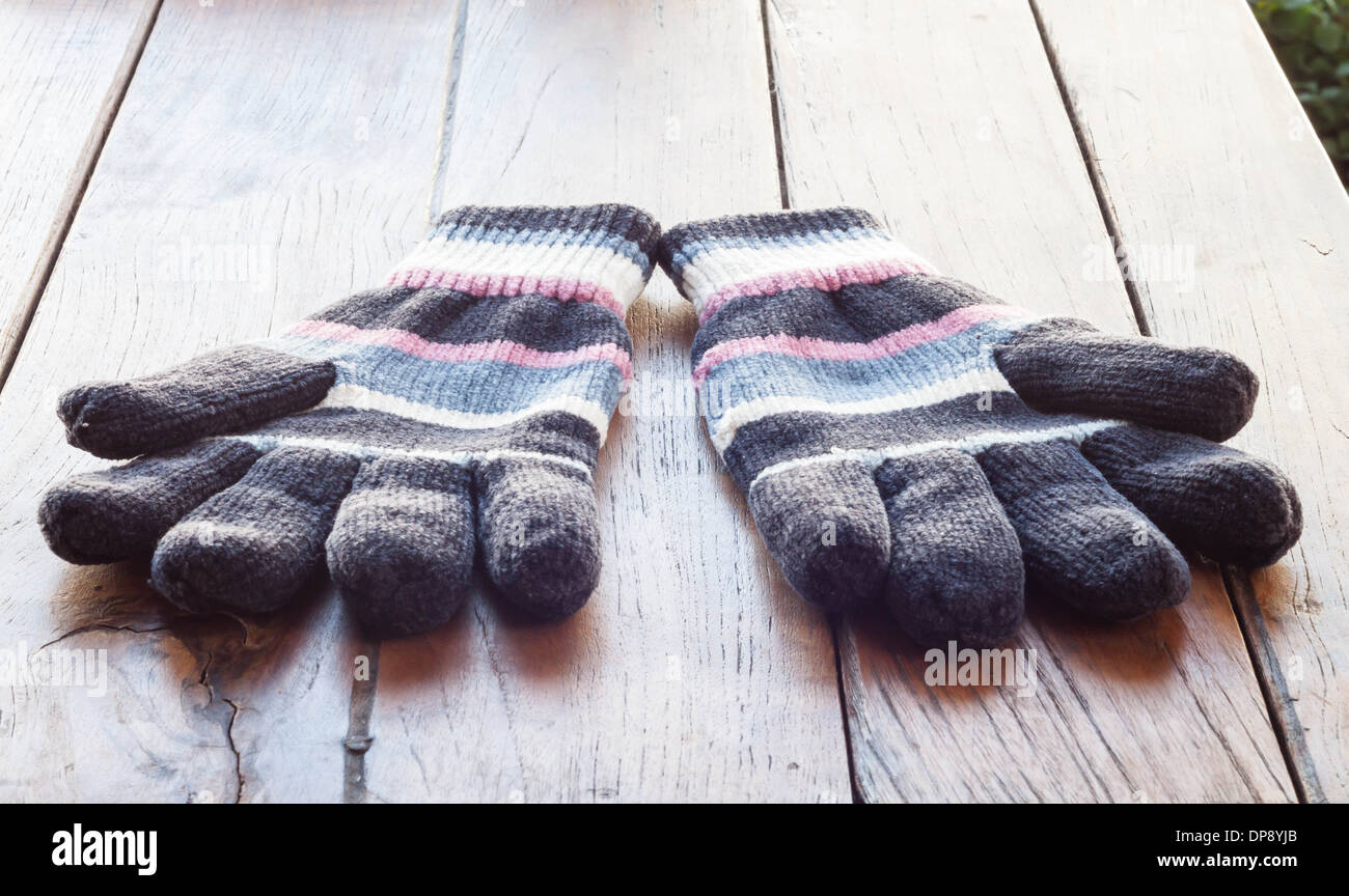Stricken Sie Handschuhe auf Holztisch, stock Foto Stockfoto