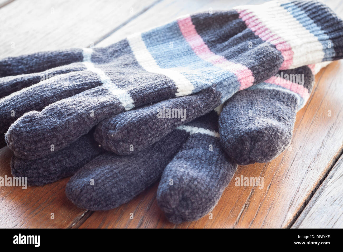 Stricken Sie Wolle Handschuhe auf Holztisch, Fotoarchiv Stockfoto