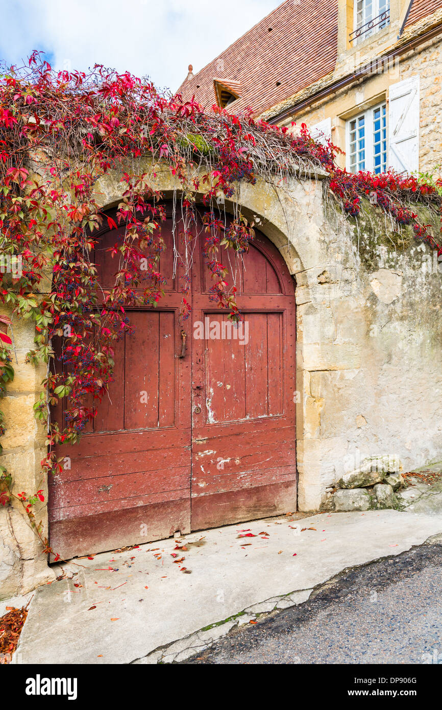 Domme, Frankreich, Europa. Schöne alte Holztor traditionell in einer alten Steinmauer. Stockfoto