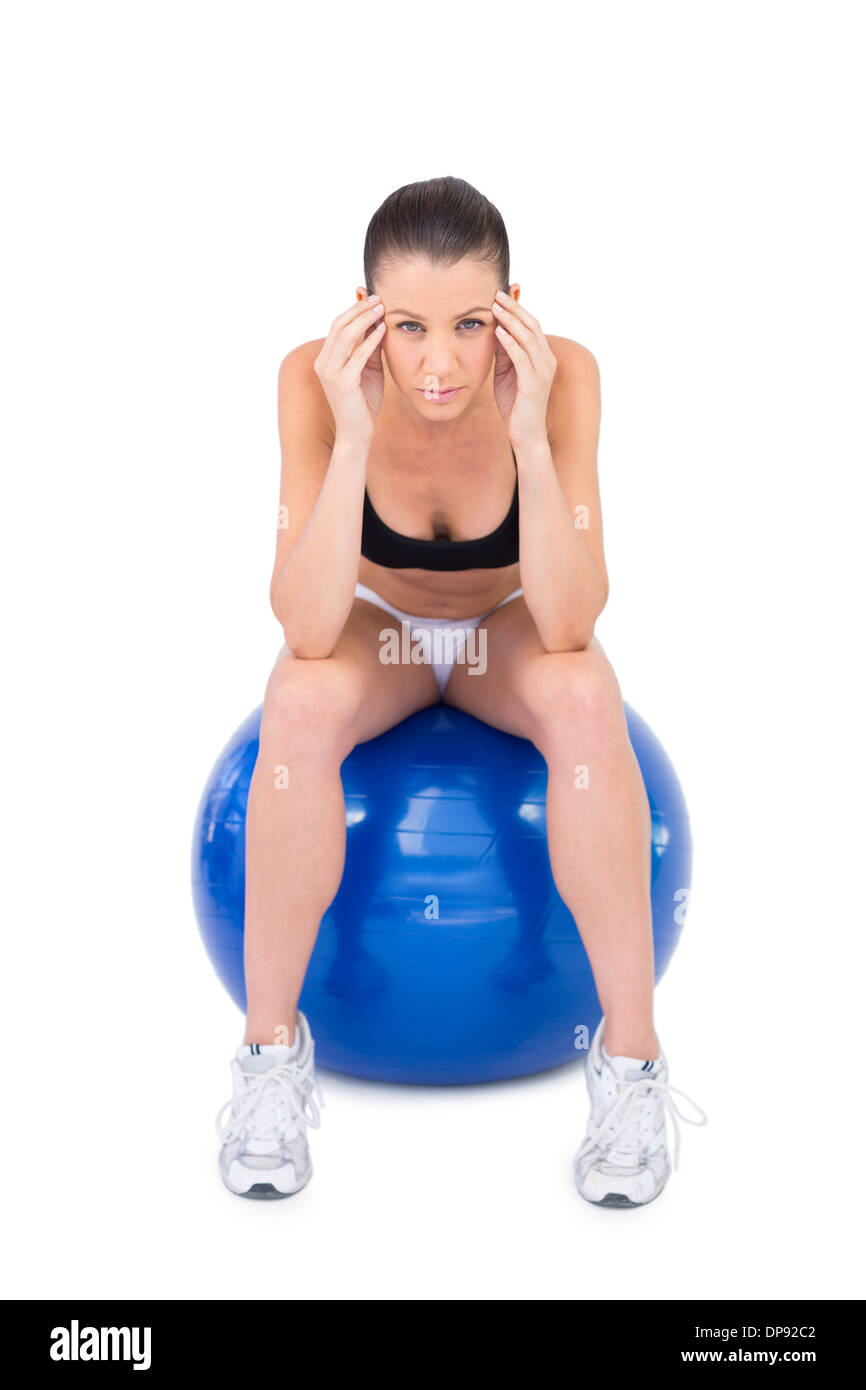 Besorgt Fit Frau sitzen auf Gymnastikball Stockfoto