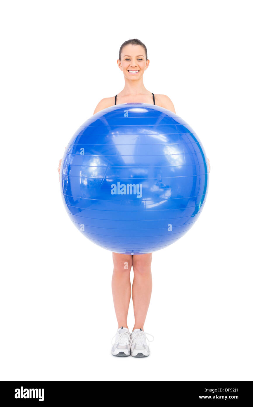 Fit Frau hält Gymnastikball vor ihr Lächeln Stockfoto