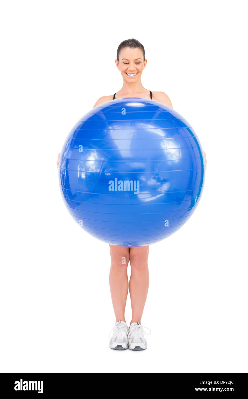 Happy fit Frau hält Gymnastikball vor ihr Stockfoto