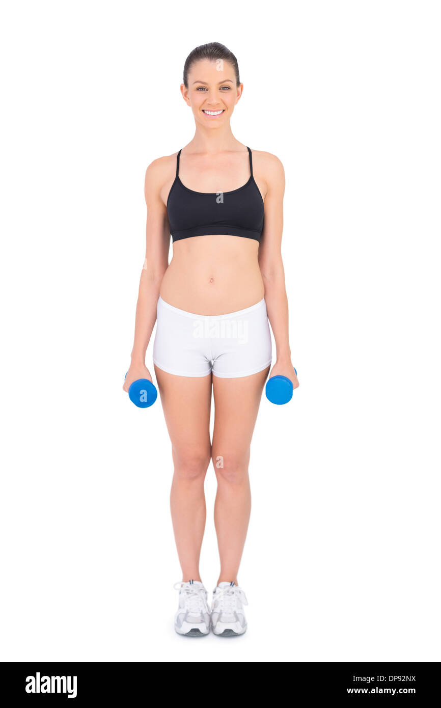 Lächelnde Frau mit Hanteln passen Stockfoto