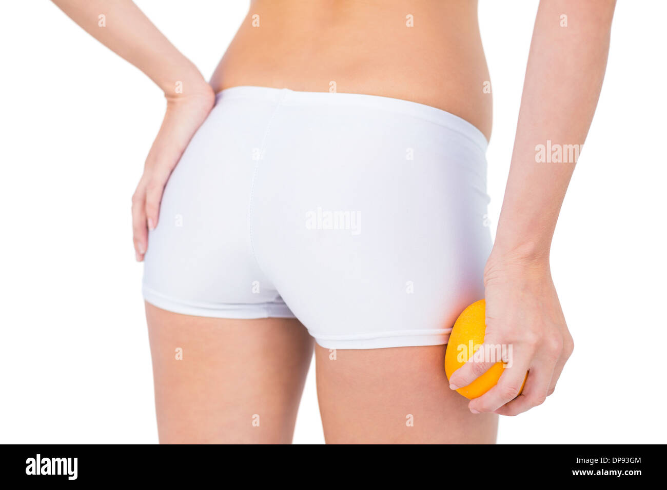Rückansicht des Fit Frau mit Orange durch den Oberschenkel Stockfoto
