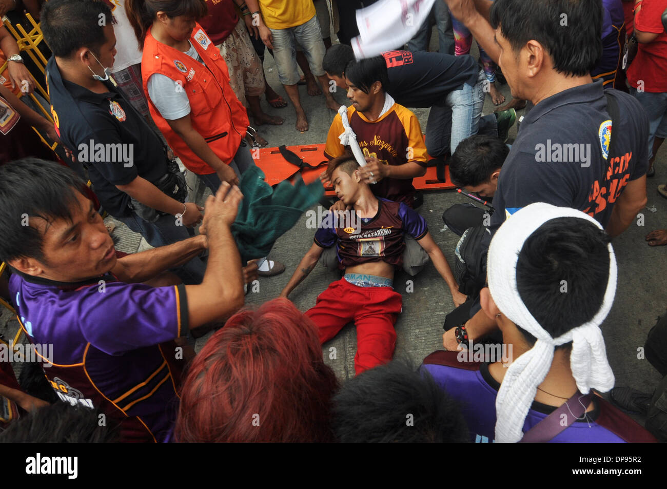 Manila, Philippinen. 9. Januar 2014. MANILA, Philippinen - Rettungsteams mit einem Mann zu besuchen, nachdem er zusammengebrochen wie katholische philippinische Anhänger Teil an der jährlichen '' Traslacion'', spanische Bezeichnung für Bewegung oder eine Passage, während das Fest des schwarzen Nazareners in Manila nehmen. Die Black Nazarene ist ein Jahrhunderte altes Bild von Jesus Christus sein Kreuz zu tragen und wird weit geglaubt, um Wunder zu vollbringen. WS-Credit: ZUMA Press, Inc./Alamy Live News Stockfoto