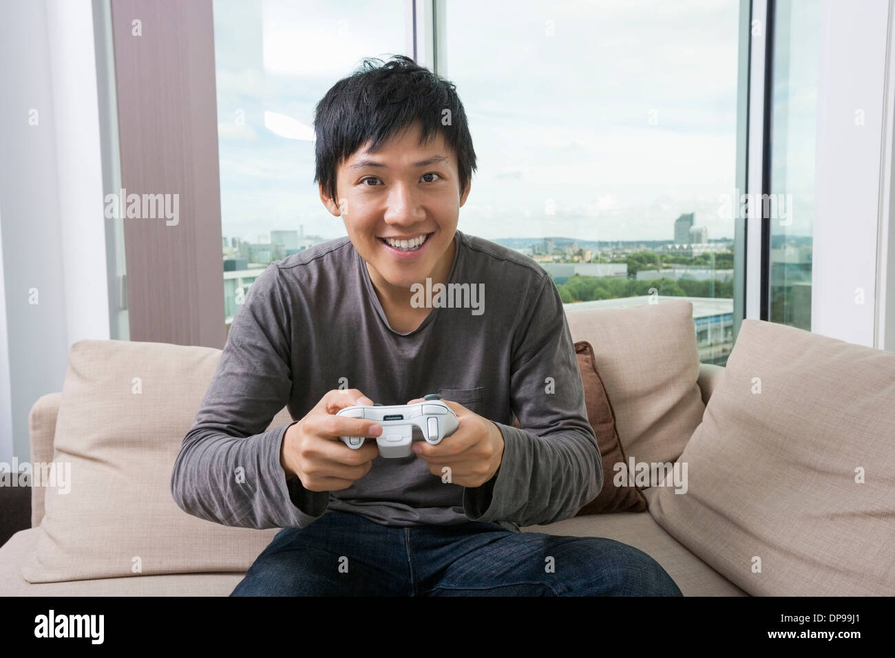 Aufgeregt Mitte erwachsenen Mannes Videospiel auf sofa Stockfoto