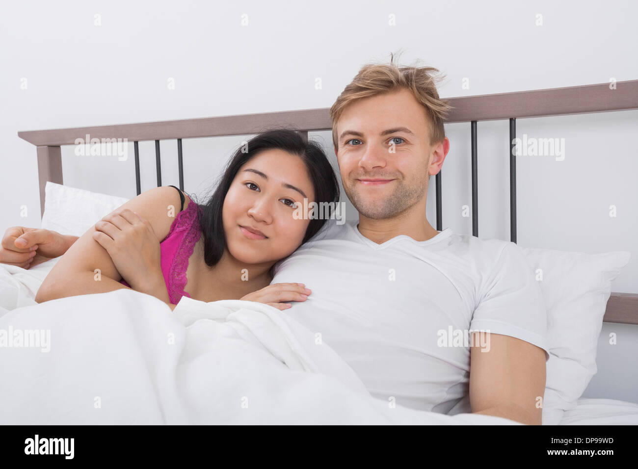 Porträt von Liebespaar im Bett Stockfoto