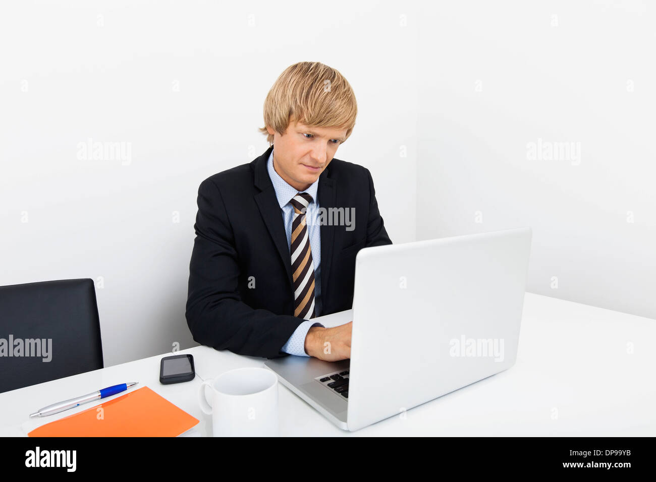 Mitte adult Geschäftsmann mit Laptop am Schreibtisch im Büro Stockfoto