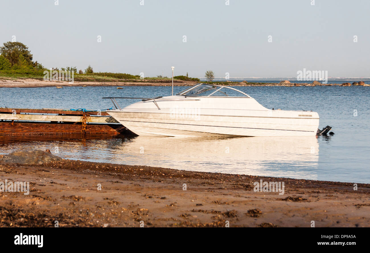 Weiße Motorboot Parkplatz neben rostigen Kai Stockfoto