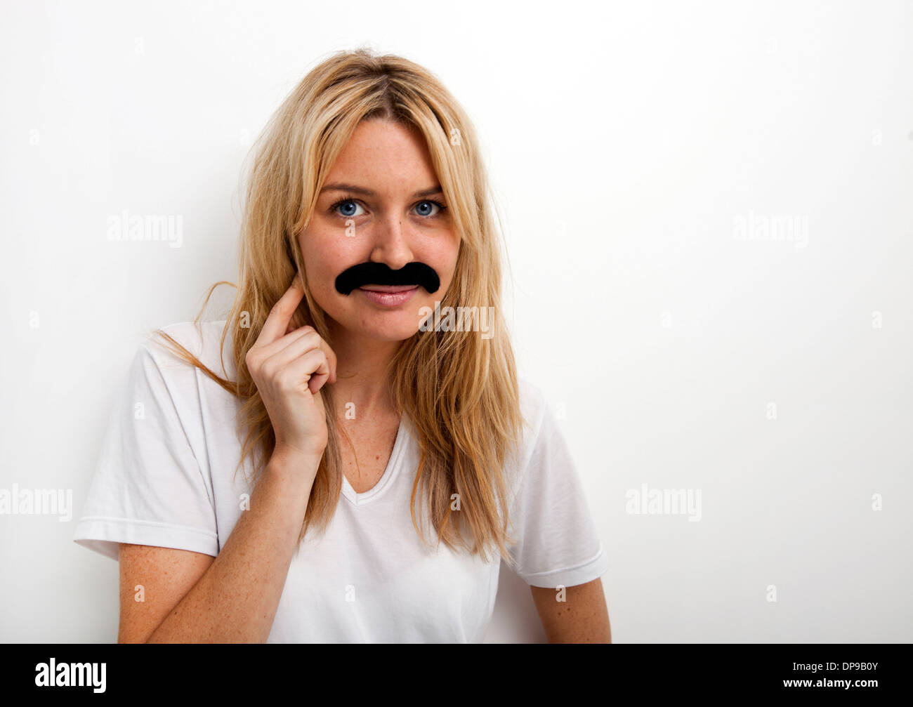 Porträt der Frau in gefälschte Schnurrbart vor weißem Hintergrund Stockfoto