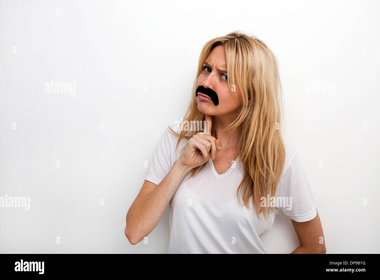 Porträt von verwirrt in gefälschte Schnurrbart vor weißem Hintergrund Stockfoto