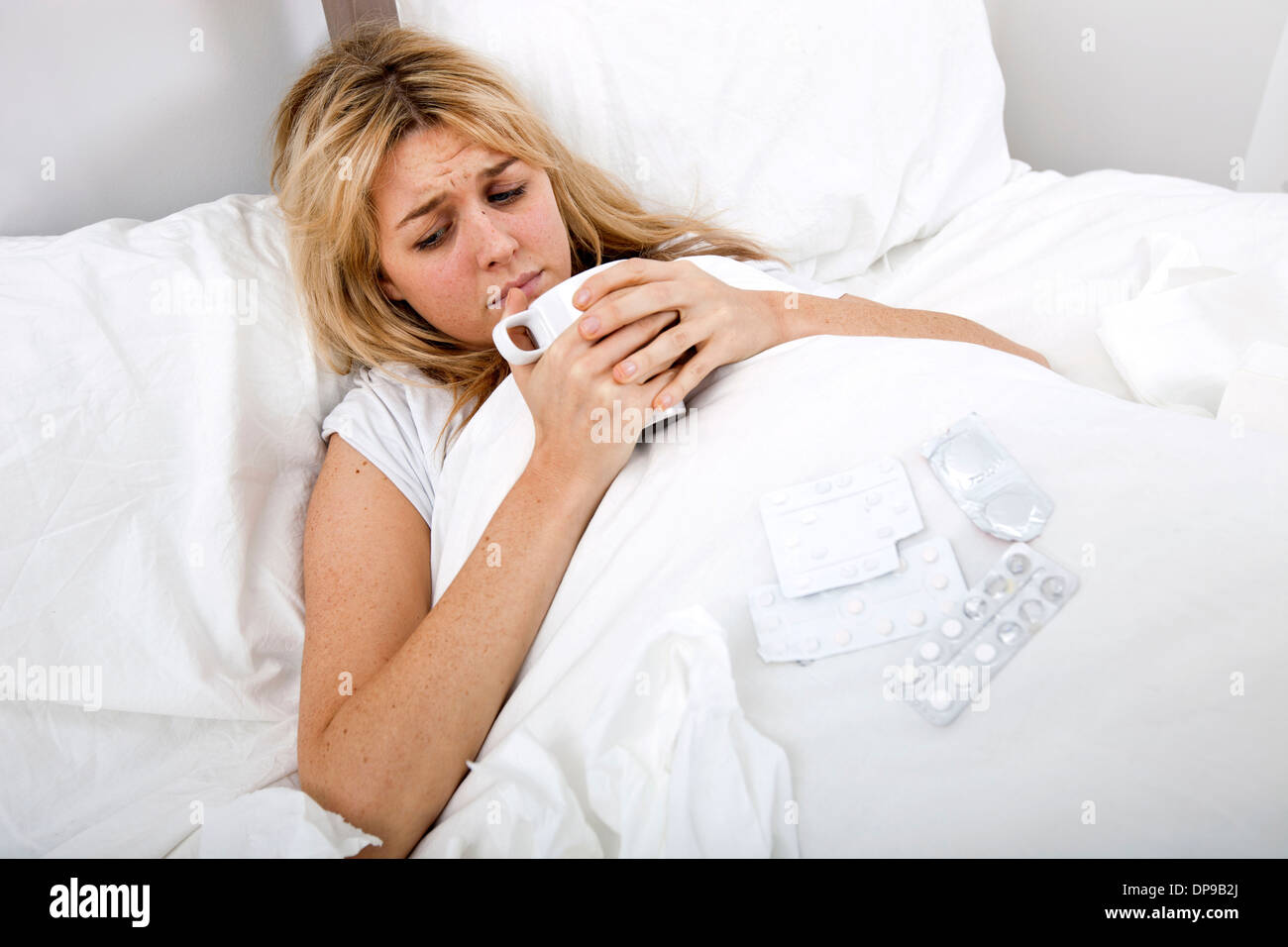 Frau leidet Kälte Kaffeetrinken im Bett Stockfoto