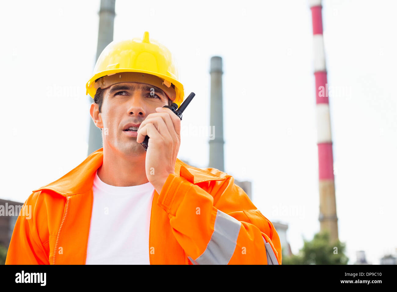 Männlichen Bauarbeiter tragen reflektierende Workwear Kommunikation über Walkie-talkie am Standort Stockfoto