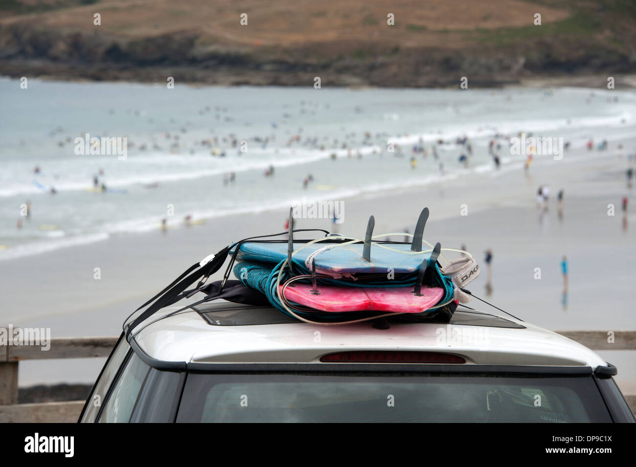 Surfbretter auf Autodach mit Blick auf Polzeath Cornwall UK Stockfoto