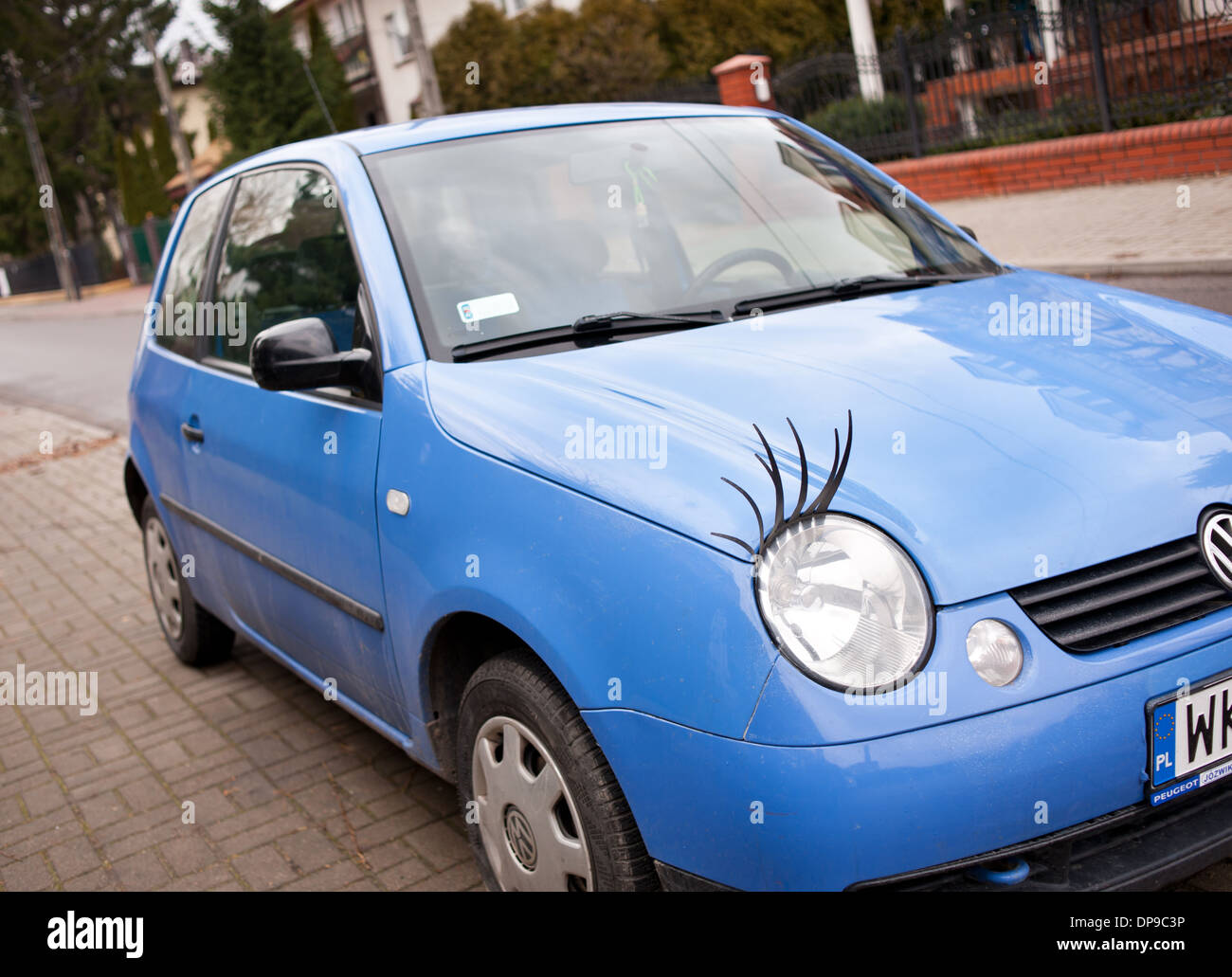 Blaues Auto mit lustigen Wimpern auf Lampe Stockfoto
