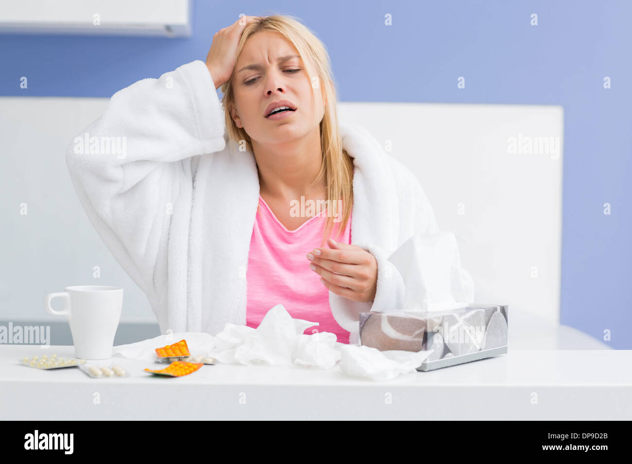Junge erschöpft Frau leiden unter Kopfschmerzen und Kälte in Küche Stockfoto