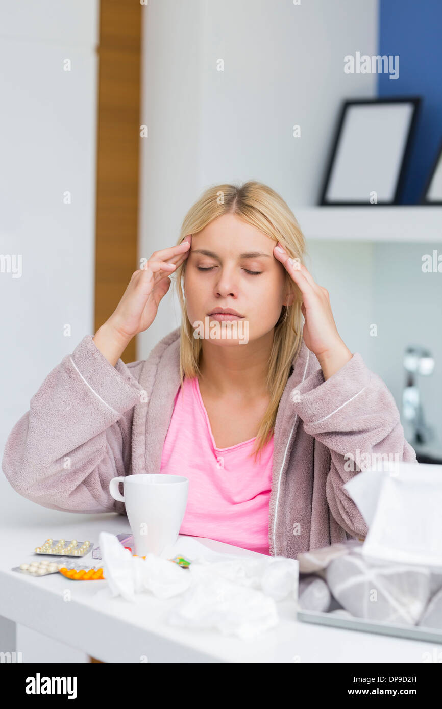 Junge Frau massiert Kopf während leiden unter Kälte Stockfoto