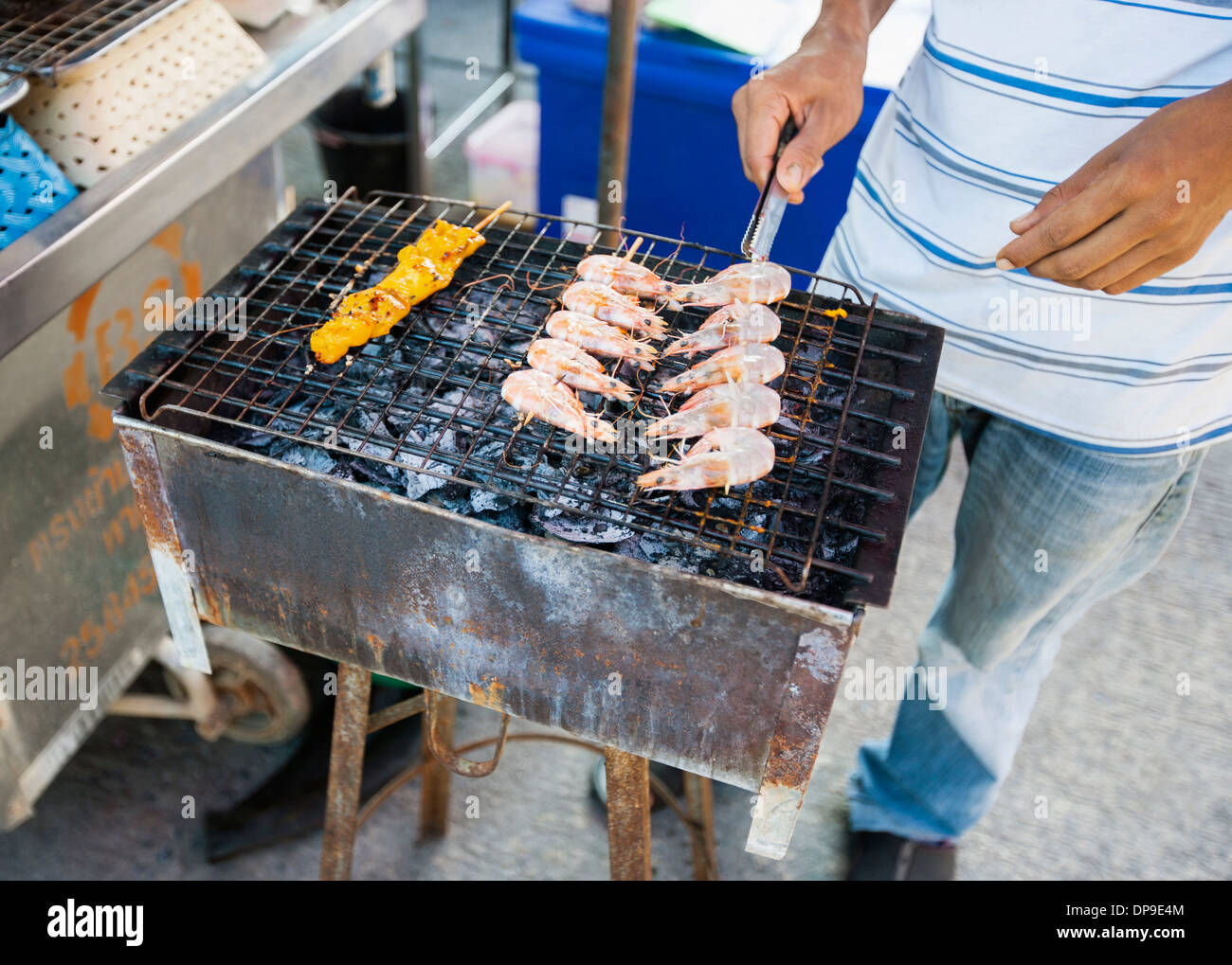 Geringen Teil junger Mann Kochen Garnelen auf Grill Thailand Koh Pha Ngan Stockfoto