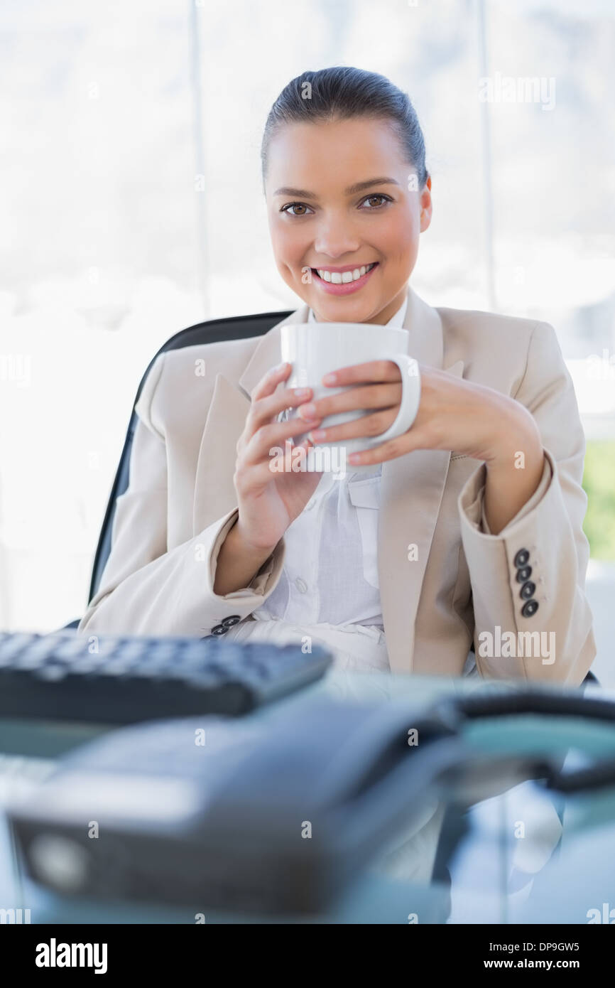 Fröhliche anspruchsvolle Geschäftsfrau halten Kaffee Stockfoto