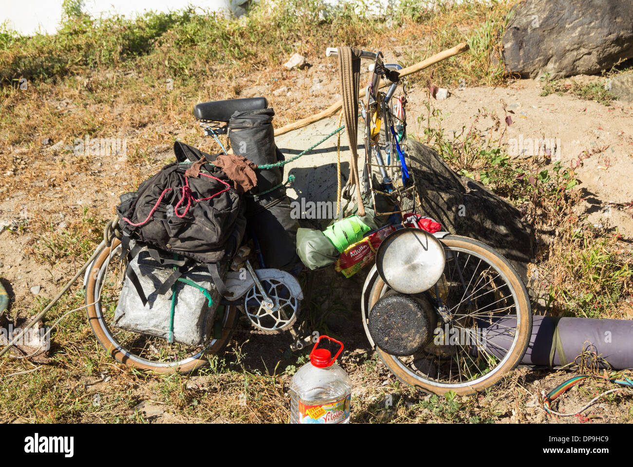 Altes Fahrrad beladen mit Campingausrüstung, Töpfen und Pfannen in der Nähe von Strand in Spanien Stockfoto