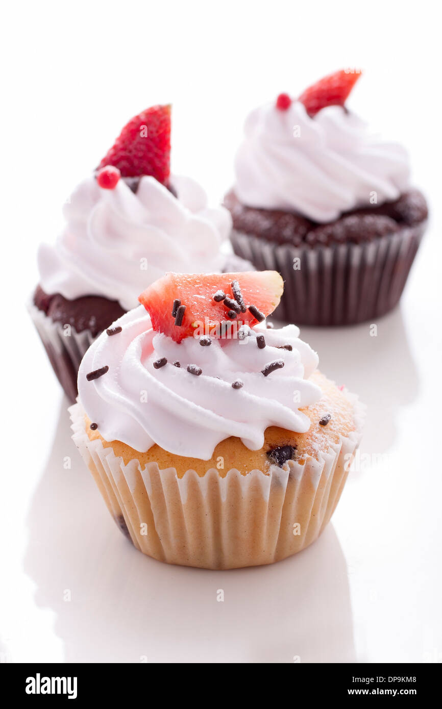 Vanille Cupcake und Schokolade Cupcake Dekoration mit Erdbeeren auf weißem Hintergrund Stockfoto