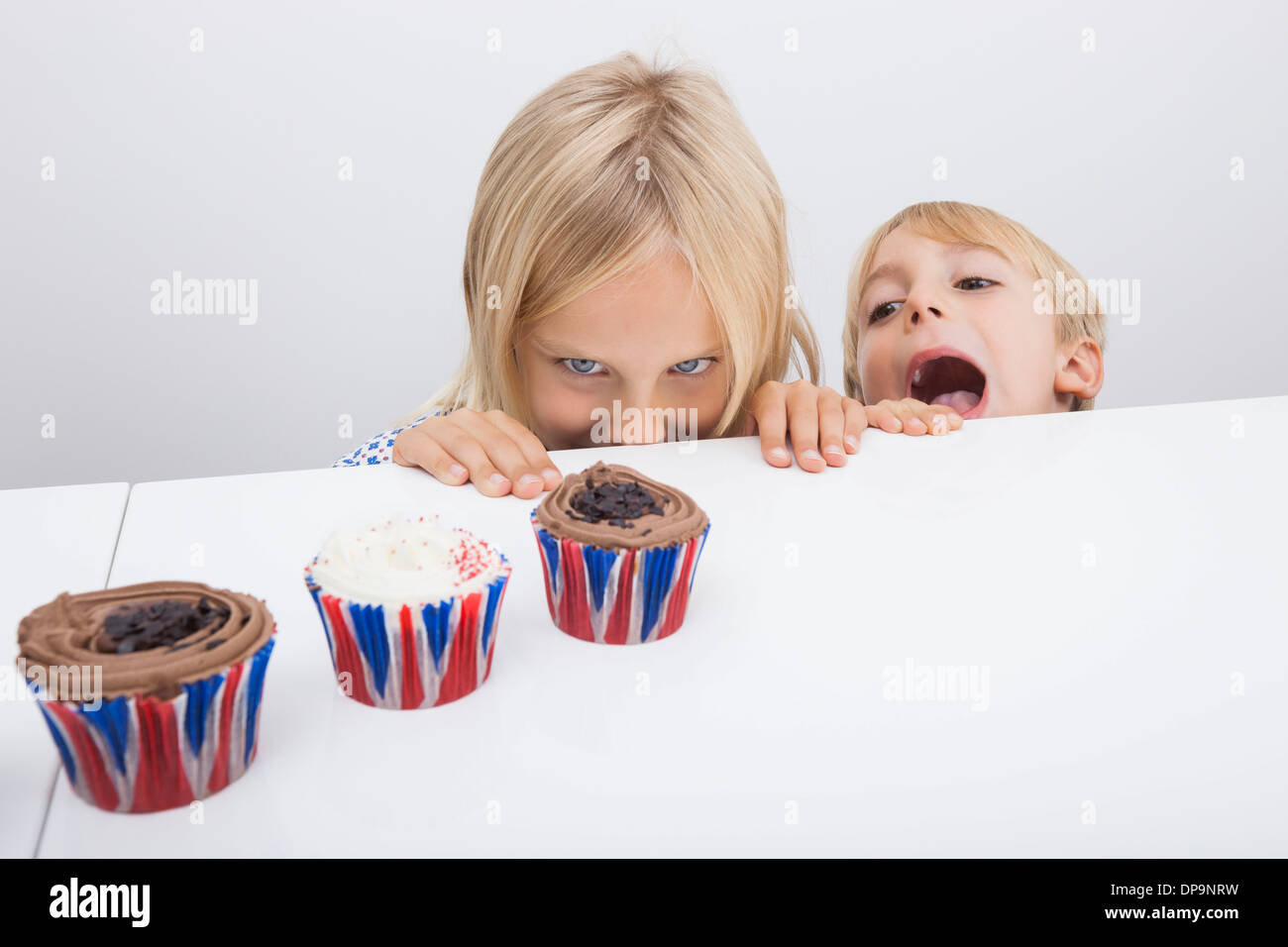 Versucht Kinder betrachten Cupcakes auf Tisch Stockfoto