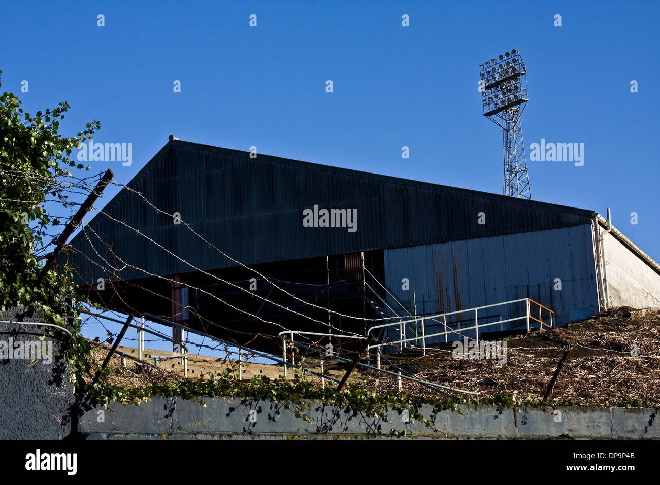 Strahler, die hoch über einem der Stände am Dens Park Football Ground Heimatstadion des FC Dundee in Schottland, Großbritannien Stockfoto