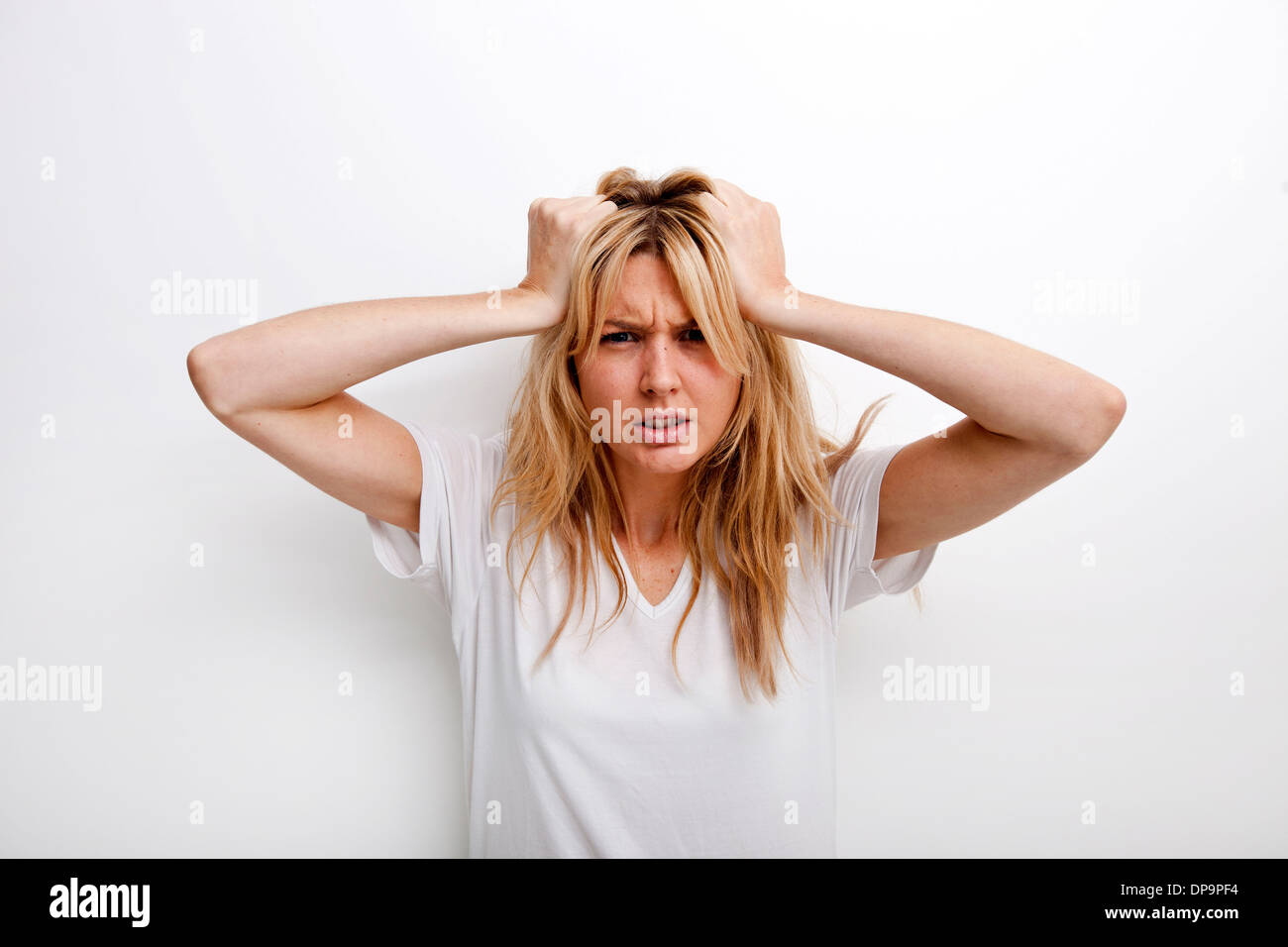 Porträt von frustrierten Frau ziehen vor weißem Hintergrund Stockfoto